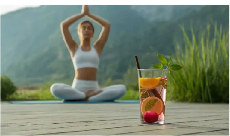 Set in a tranquil natural environment, this image features a person engaged in yoga beside a clear glass of Ozzi Crave Crusher.